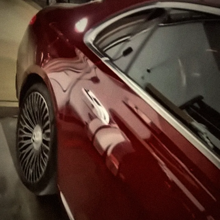 Red Mercedes with multi-spoke wheels outside the shop at night